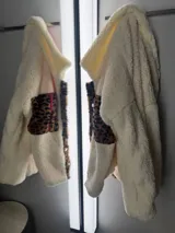 Campera de corderito color crudo, forrada con polar y detalles en sherpa con estampado animal print.