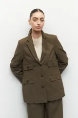 Blazer gris oscuro de corte clásico, con solapas de muesca, cierre con dos botones a tono, bolsillos de solapa decorativos y mangas largas.