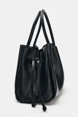 Bolso tipo shopper de cuero sintético en color azul oscuro, con diseño fruncido, doble asa de mano y cordones ajustables a los lados.