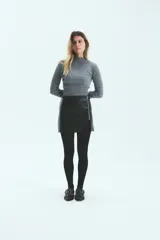 Falda corta de ecocuero con textura tipo croco, diseño cruzado con cierre metálico frontal y tajo lateral.