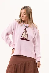 Buzo de punto rosado con diseño frontal de velero, cuello redondo y puños en contraste color bordó.