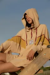 Hoodie de tela de toalla color azul, con cuello alto y cierre frontal de cremallera amarilla. Presenta bloques de color rojo en los hombros y detalles de ribetes amarillos. Tiene un bolsillo tipo canguro y un parche decorativo en el pecho.