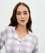 Conjunto de pijama estilo americano compuesto por camisa de manga larga con cierre frontal de botones y pantalón largo con cintura elástica. Presenta un estampado de cuadros en tonos gris y blanco.