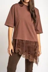 Remera marrón oversize de algodón peinado con cuello redondo, mangas cortas y detalle de ruedo asimétrico en satén con aplicación de encaje.