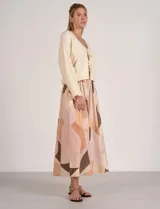 Falda larga de tiro alto con cintura elastizada y bolsillos laterales, con diseño estampado de formas abstractas en tonos cálidos y neutros.