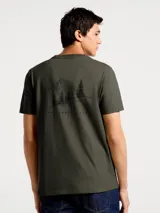 Camiseta blanca de algodón con cuello redondo y mangas cortas. Estampa rectangular con borde negro que contiene la frase "NATURAL ATMOSPHERE" en letras mayúsculas y una imagen de montañas y mar.