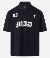 Remera de corte boxy confeccionada en algodón, con cuello polo y cierre frontal de botones. Presenta un diseño estampado en el frente con el número 93, una cruz y la palabra MAD en tipografía gótica.