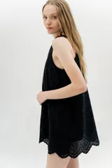 Vestido corto negro con bordado calado, sin mangas y corte evasé.