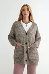 Cardigan de punto jaspeado en tonos marrones y grises, con escote en V, cierre frontal de botones oscuros y bolsillos delanteros amplios.