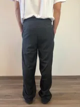 Pantalón sastrero de corte recto y holgado, color gris claro, con pinzas frontales y cintura con elástico posterior.