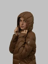 Campera marrón de nailon con relleno de plumón (90% plumón, 10% plumas), cierre frontal con cremallera, diseño acolchado, bolsillos laterales y cuello alto con capucha.