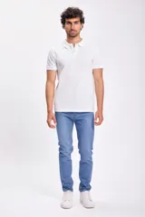 Pantalon jean de corte slim en color azul medio, con diseño clásico de cinco bolsillos y cierre frontal con botón y cremallera.