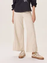 Pantalón ancho de denim azul oscuro, con corte holgado y costuras contrastantes en blanco y rojo en la zona de la bragueta.