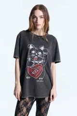 Remera de jersey de algodón con efecto lavado, corte oversize, cuello redondo y manga corta. Presenta un estampado frontal de un gato con un corazón rojo.