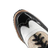Zapato tipo Oxford de cuero color beige con detalles en charol negro y blanco, con cordones negros y taco bajo de madera.