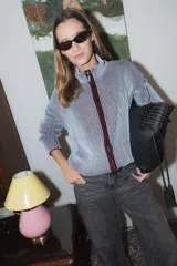 Campera tejida de punto con textura de rayas verticales, cierre frontal completo y cuello alto. Diseño de manga larga con hombros caídos.