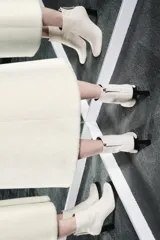 Botín de cuero color crema con puntera cuadrada y cierre de cremallera en la parte trasera. El tacón es ancho y de color negro. La altura del tacón es de 8,5 cm.