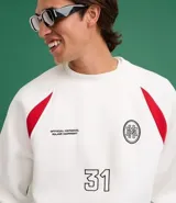 Saco deportivo boxy de algodón felpa color blanco, con cuello redondo, manga raglán larga y recortes rojos en los hombros. Presenta bordados frontales con texto "OFFICIAL NATIONAL MAJOR HARMONY", un logo circular y el número "31". Las mangas tienen un patrón de cuadros rojos y blancos.