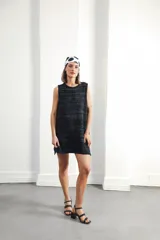 Vestido corto sin mangas, de tejido de punto en color azul marino con efecto jaspeado o tweed en tonos claros. Presenta un corte amplio y relajado, con cuello redondo y bordes en contraste.