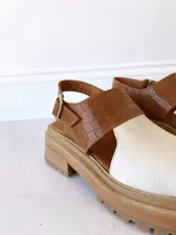 Sandalias de cuero color camel y crudo, con plataforma track y hebilla ajustable.