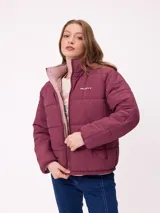 Campera puffer reversible de la marca Rusty, con diseño capitoneado. Presenta cuello alto, cierre frontal completo y logo bordado en el pecho. El interior es de un tono contrastante.