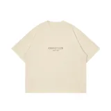 Remera oversize de color arena, 100% algodón, con estampa en la espalda que ilustra el puente de La Barra durante el atardecer, acompañada de texto descriptivo y de la marca Eseele Club.