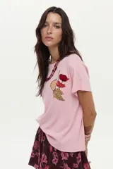 Remera de algodón color rosado, de manga corta, con cuello redondo y detalle de estampa y bordado frontal con diseño de una flor y una higuera.