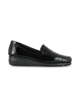 Mocasines tipo slip-on de cuero charol negro, con suela anatómica de goma y talón curvado para mayor comodidad.