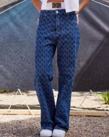 Jean de tiro bajo y corte oversize, confeccionado en denim azul con monograma grabado a láser en toda la prenda. Presenta doble botón metálico en la cintura y diseño de cinco bolsillos.