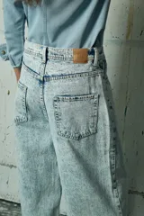 Jean de corte wide leg en color gris lavado, con diseño de tiro alto y cinco bolsillos.