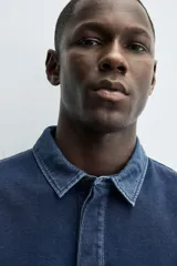 Sudadera polo azul marino de corte regular fit, con cuello solapa en contraste y cierre frontal de botonadura oculta. Tiene manga larga con puños acanalados y un efecto lavado.