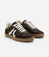 Championes de estilo retro inspirados en calzado de fútbol, confeccionados en poliuretano color verde menta con detalles laterales en rosado. Presentan suela plana de goma color caramelo y cierre mediante cordones al tono.