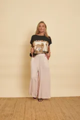 Blusa de manga corta color negro con panel frontal estampado con diseño de leopardos y motivos botánicos en tonos beige y negro.