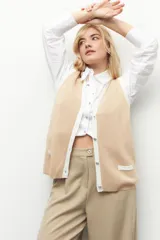 Pantalón sastrero ancho color verde oliva, de tiro alto, con pretina ancha de un botón, bolsillos laterales y pinzas en el frente.