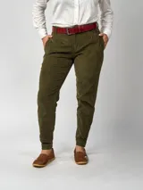 Pantalón de pana negro de corte recto, con bolsillos laterales y traseros. Se ajusta a la cintura con cinturón de cuero negro.