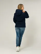 Campera ligera acolchada de Tommy Hilfiger en color azul marino. Presenta un diseño con cierre frontal de cremallera, cuello alto con capucha ajustable mediante cordones y dos bolsillos laterales con cierre. El diseño incluye costuras horizontales y diagonales que definen su estructura acolchada.