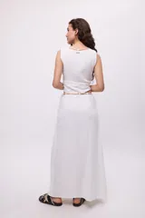 Top blanco de algodón con escote en V y tiras decorativas cruzadas en el frente.