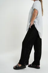 Pantalón negro de tejido calado con cintura elástica.