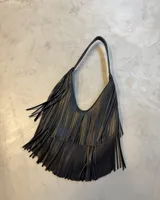 Bolso de hombro negro con diseño de flecos largos que cubren la mayor parte del cuerpo del bolso. Tiene un asa corta y curva.