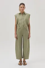 Blusa verde militar sin mangas, confeccionada en lino, con cuello camisero, cierre frontal con botones y corte holgado.