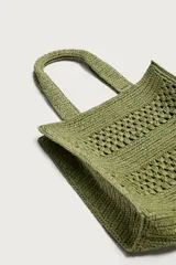 Bolso tipo shopper de color naranja con acabado trenzado y diseño estructurado. Cuenta con compartimento principal y dos asas cortas de mano.