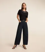 Blusa blanca de mangas cortas confeccionada en viscosa con cuello redondo con brillos en formas florales.