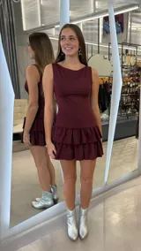 Vestido corto bordó sin mangas, de corte ajustado en el torso y falda corta con doble volado.