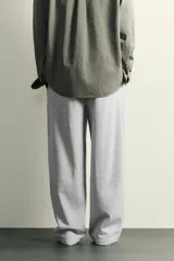 Pantalón jogger de corte relajado y pernera ancha, confeccionado en tejido de algodón con interior perchado. Cuenta con cintura elástica ajustable mediante cordón interior, bolsillos laterales y un bolsillo trasero de plastrón.