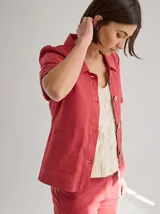 Chaqueta de lino color negro con costuras a contratono, mangas cortas con dobladillo y detalle de franja texturizada en la cintura. Presenta cuello camisero y etiqueta de cuero en la espalda.