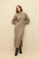 Vestido largo de punto color gris, con cuello alto, mangas largas y aberturas laterales en el ruedo.