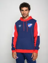 Canguro con capucha de felpa, diseño tricolor en azul, rojo y blanco. Cuenta con bolsillo frontal tipo canguro, cordones ajustables en la capucha y logo de Umbro junto al escudo del Club Nacional de Football bordados en el pecho.