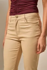 Pantalón negro de efecto cuero, tiro medio, con corte recto y ligeramente acampanado en la parte inferior.