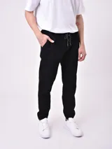 Pantalón jogger negro con cintura elástica ajustable con cordón y puños ajustados.
