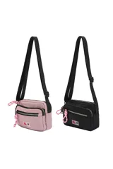 Bandolera color lila de poliéster con correa ajustable negra, cierre principal y bolsillo frontal con cierre. Detalle de cordón rosa y logo bordado.